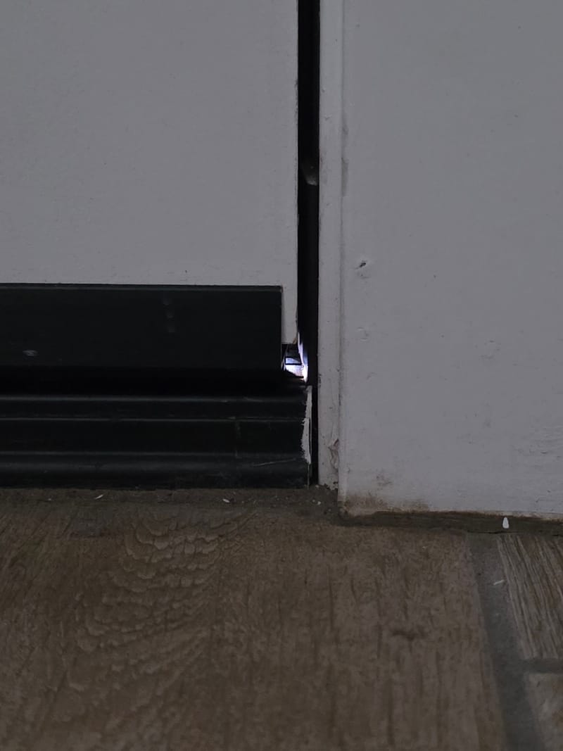 Light showing through the gap at the bottom edge of an exterior door