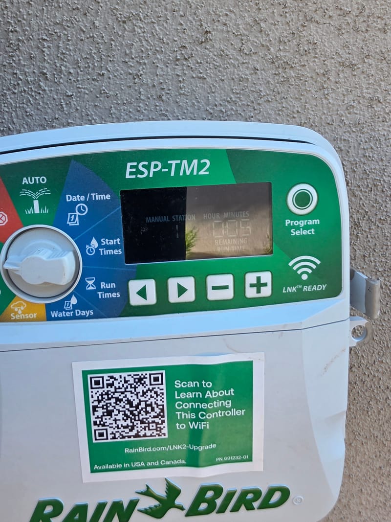 Rain Bird irrigation controller with its display on a stucco wall